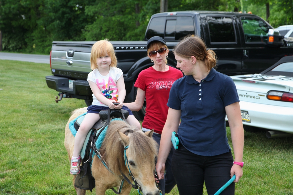 Enjoying a pony ride before the show.  Pictured: Olivia Beck (great-granddaughter of founders William and Alice Beck), alongside her mother Mindy Mertz-Beck.